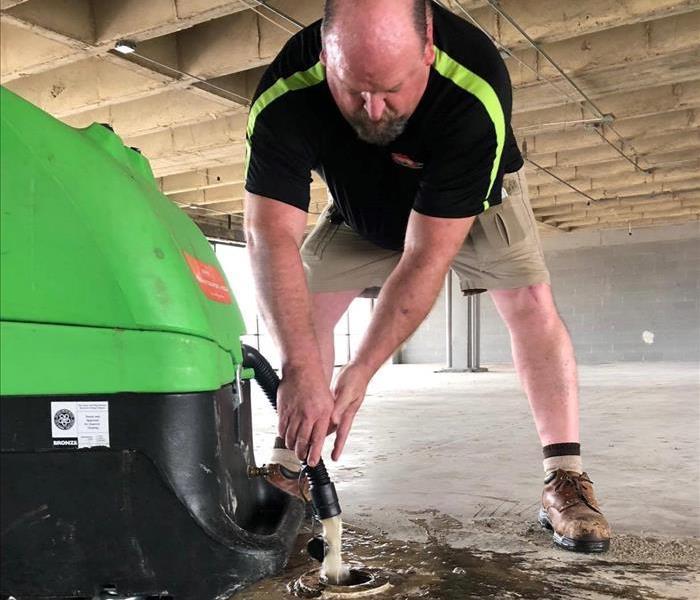 Owner of SERVPRO of Midtown Memphis draining water from equipment 