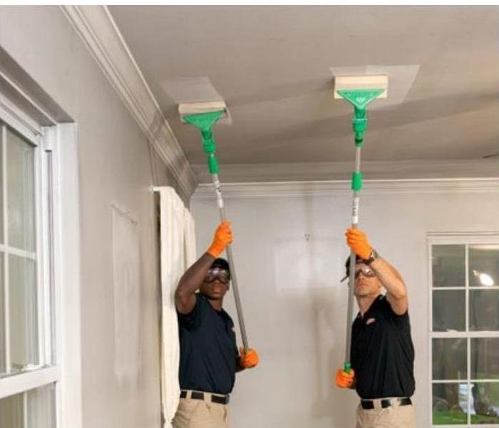 SERVPRO crew cleaning soot off of ceiling